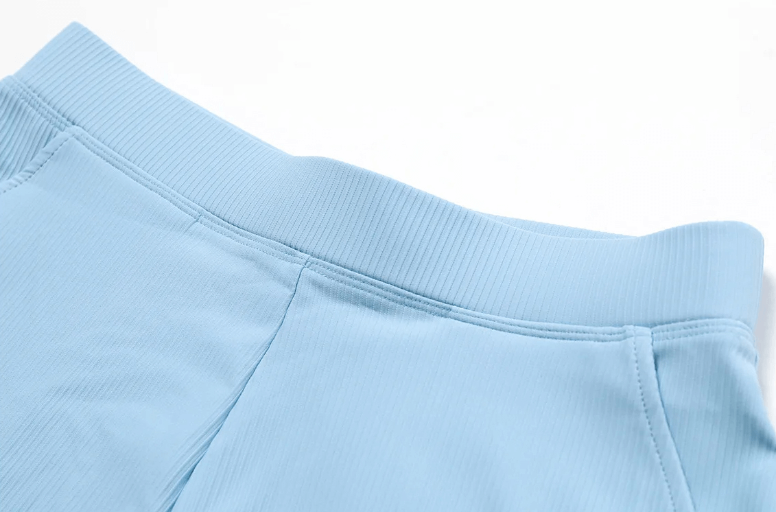 Close-up of light blue ribbed high waist workout shorts with side pockets for women, ideal for yoga and fitness.